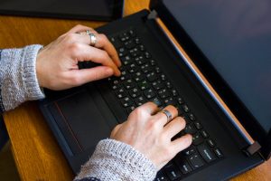 Kobieta pracująca w biurze z cyfrowym tabletem i notebookem pisząc i pisząc na urządzeniu