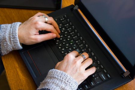 Kobieta pracująca w biurze z cyfrowym tabletem i notebookem pisząc i pisząc na urządzeniu