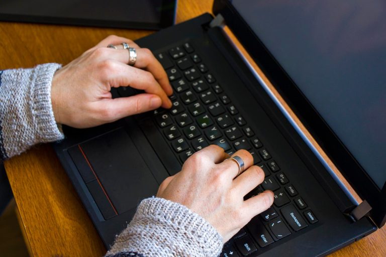 Kobieta pracująca w biurze z cyfrowym tabletem i notebookem pisząc i pisząc na urządzeniu